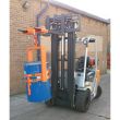Forklift-mounted crane drum tilter with adjustable hook attachment holding blue drum for efficient material handling operations.